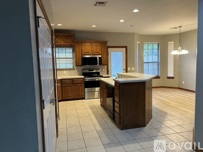 A kitchen with wooden cabinets and a large island.
