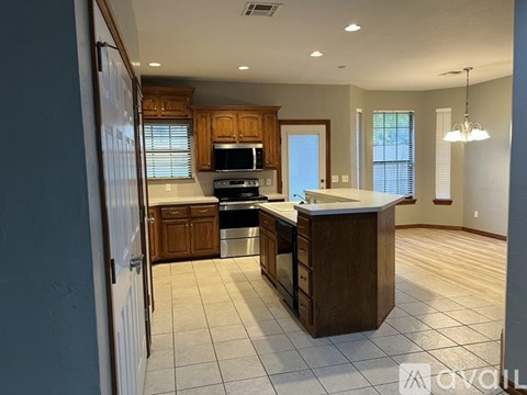 A kitchen with wooden cabinets and a large island.