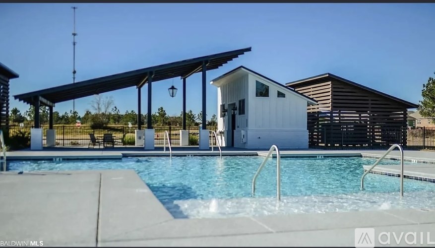A pool with a diving board and a building in the background.