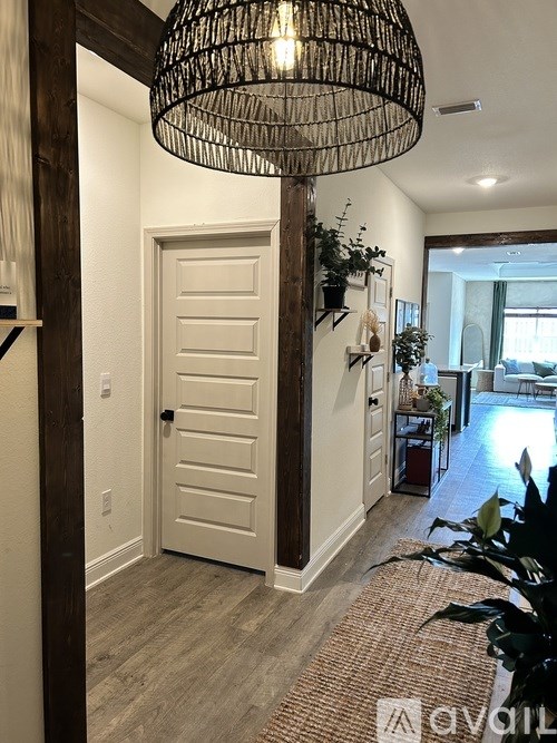 A white door is in a hallway with a light on the ceiling.