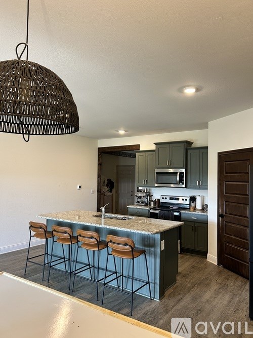 A kitchen with a bar area and chairs.