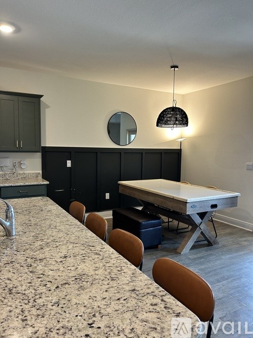 A dining room with a table and chairs.