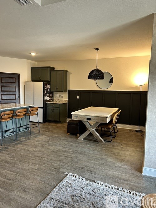 A kitchen with a table and chairs.