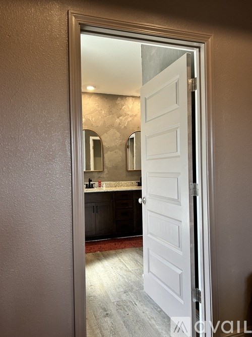 A white door is open to a bathroom.