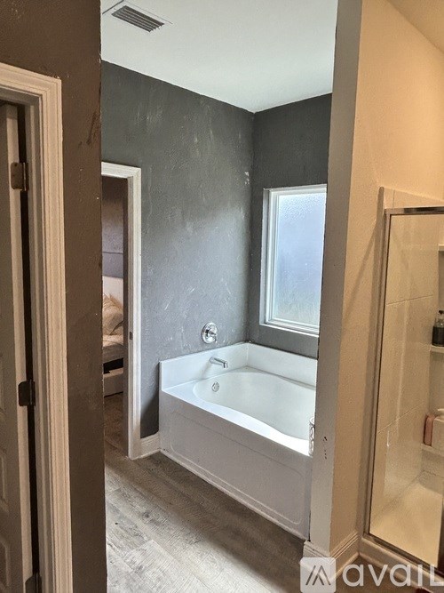 A bathroom with a bathtub and a window.