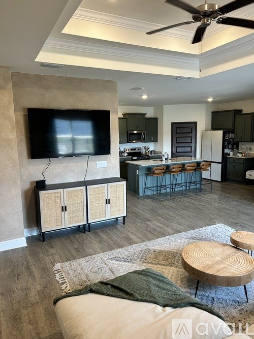 A living room with a television, a cabinet, and a rug.