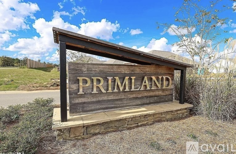 A wooden sign that says "Primland" is in front of a grassy area.