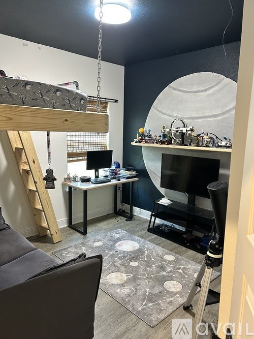 A room with a workbench, a chair, and a large white circular object on the wall.