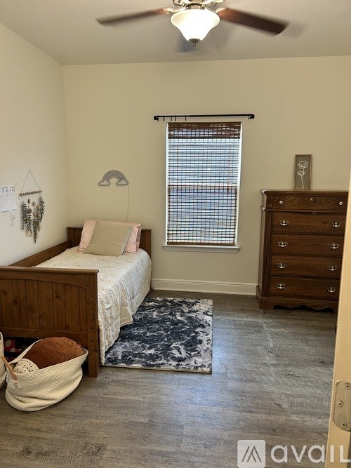 A bedroom with a bed, dresser, and window.