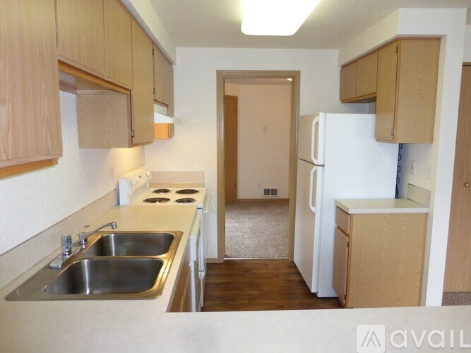 A kitchen with a sink, stove and refrigerator.