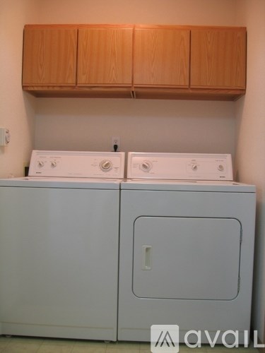 Two white washing machines in a laundry room.
