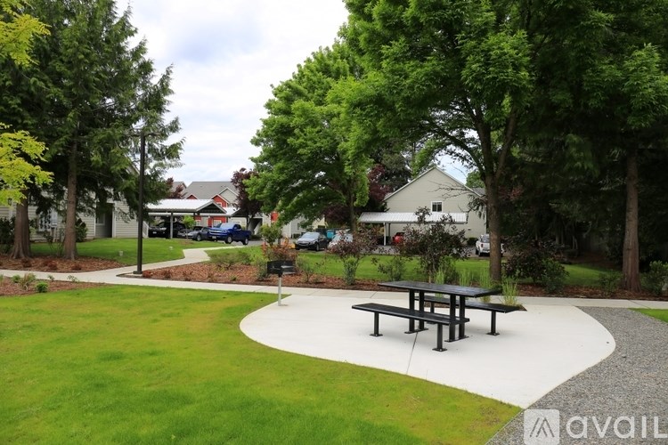 A park with a picnic table and a gravel path.