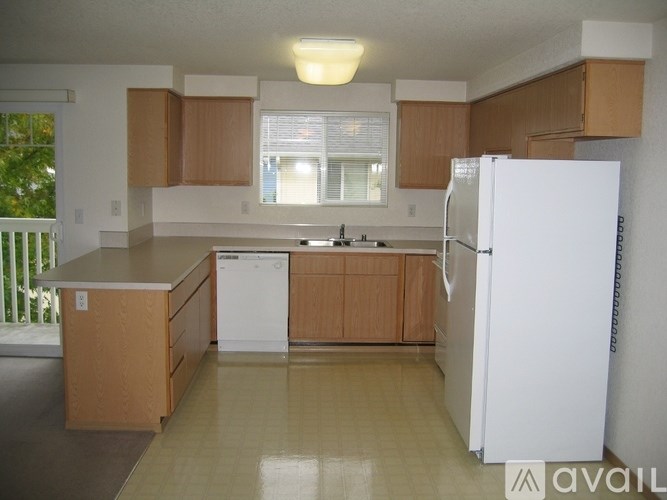 A kitchen with wooden cabinets and a white refrigerator.
