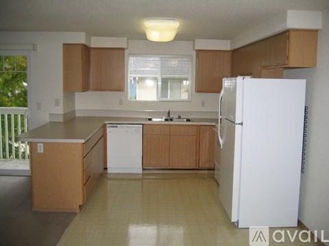 A kitchen with wooden cabinets and a white refrigerator.