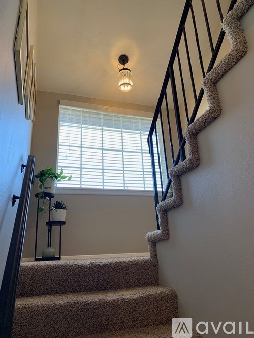 A staircase with a carpeted runner and a metal railing.