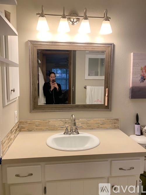 A person is taking a picture of a bathroom in a mirror.
