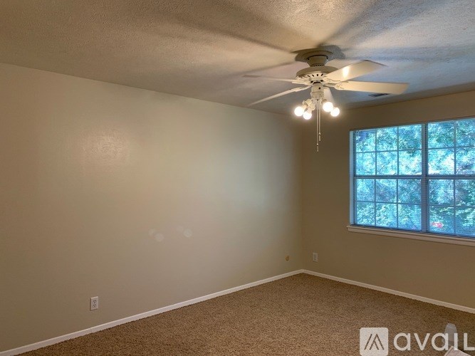 A room with a ceiling fan and carpeted floor.