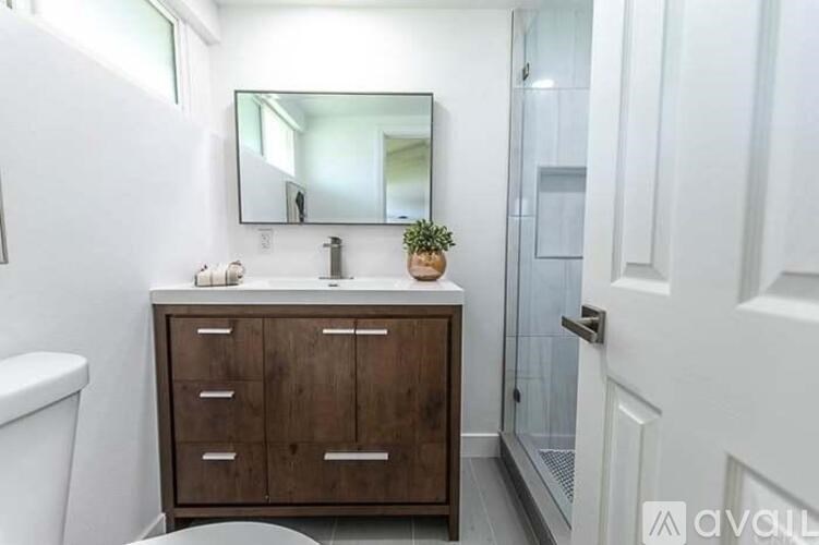 A room with wooden flooring and white walls.