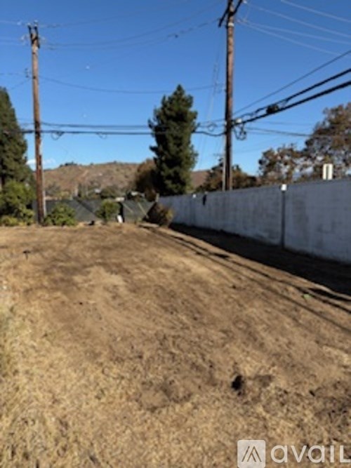 A dirt field with power lines in the background.