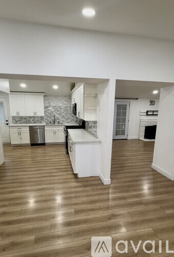 A bathroom with a toilet, sink, and a painting on the wall.