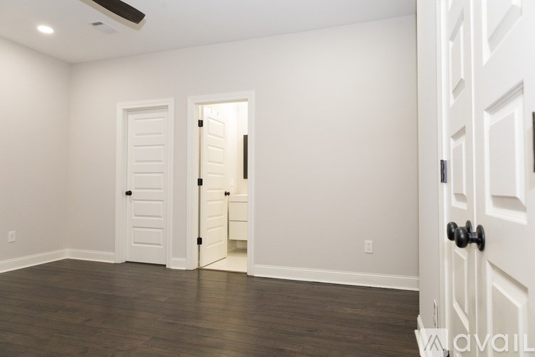 A room with a white door and a black handle.