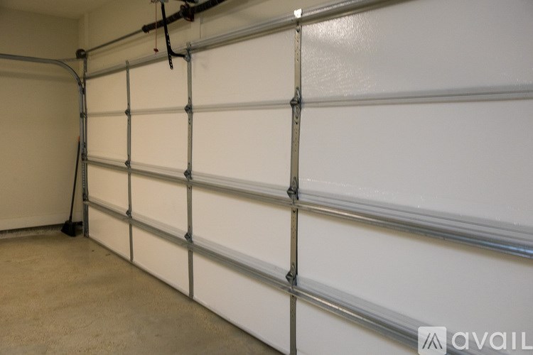 A white garage door with a silver roller on the side.