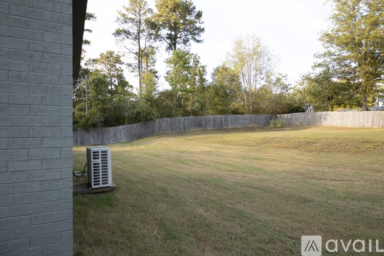 A backyard with a wooden fence and a tree.