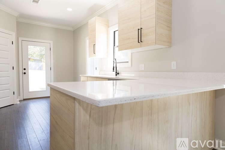 A kitchen with a white countertop and wooden cabinets.