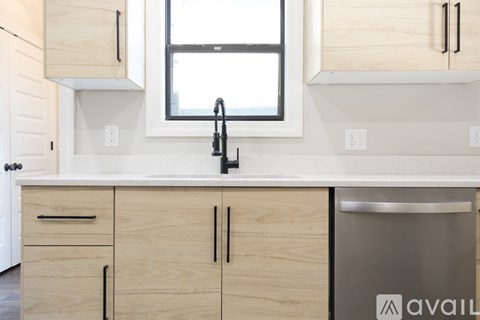 A kitchen with wooden cabinets and a window above the sink.