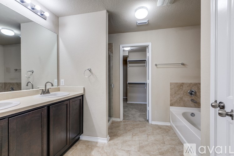 A bathroom with a sink, mirror, and bathtub.