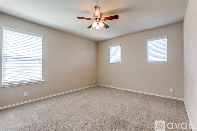 A room with a ceiling fan and carpeted floor.