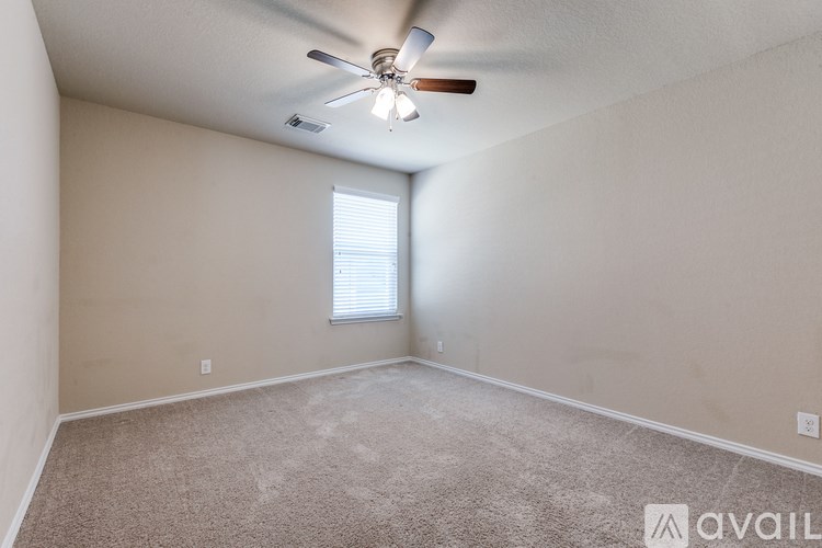 A room with a ceiling fan and a window with blinds.