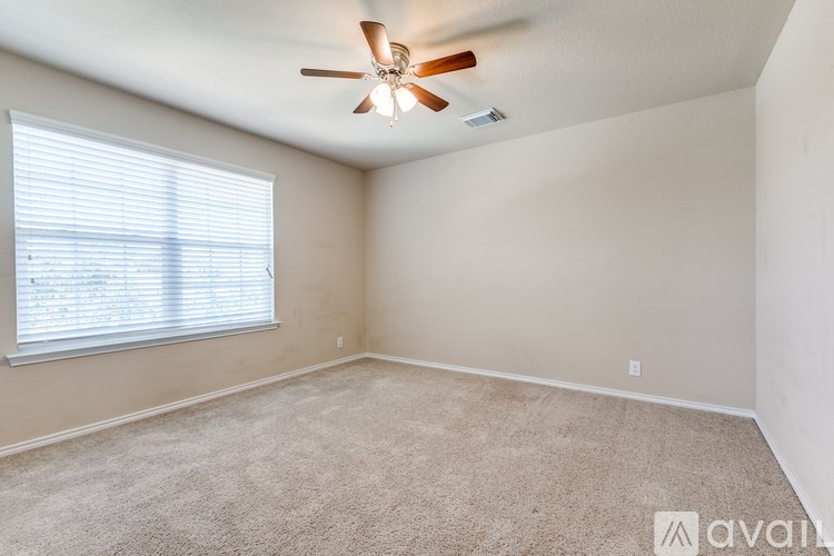 A room with a ceiling fan and carpeted floor.