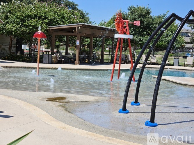A pool with a red umbrella and a lifeguard tower.