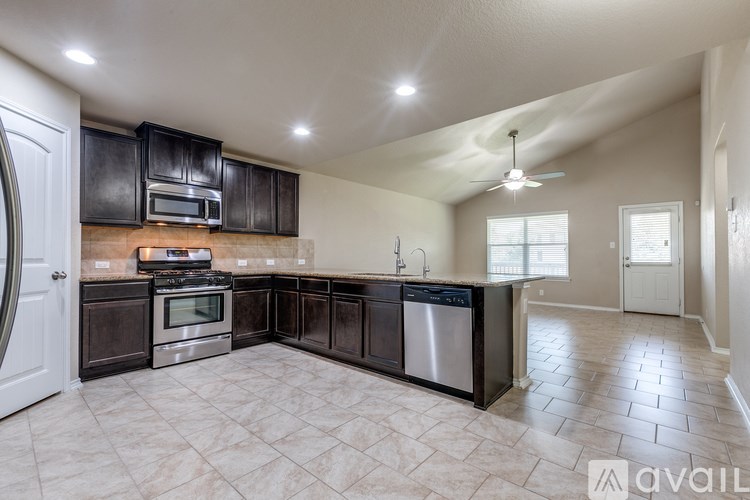 A kitchen with black cabinets and a tiled floor.