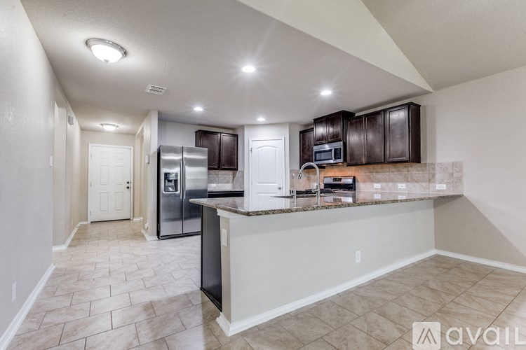 A kitchen with a refrigerator, microwave, and oven.