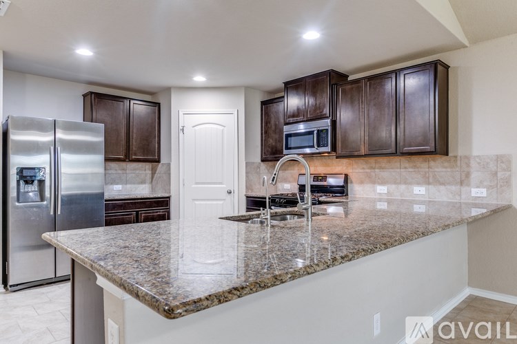 A kitchen with granite countertops and stainless steel appliances.