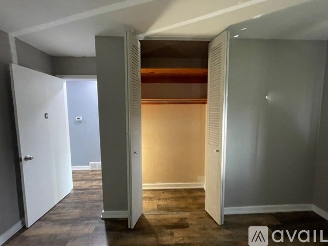 A room with a white door and a brown carpet.