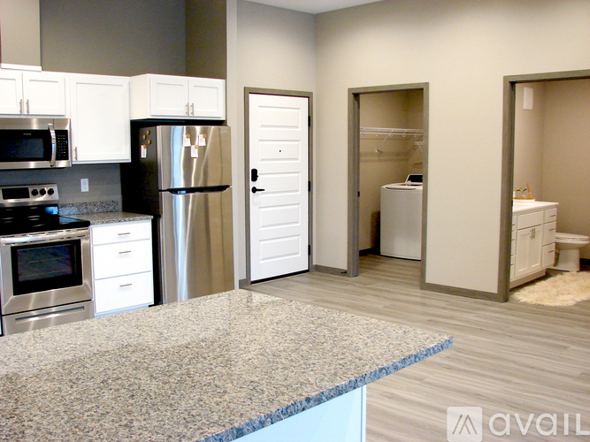 A kitchen with a granite countertop and stainless steel appliances.