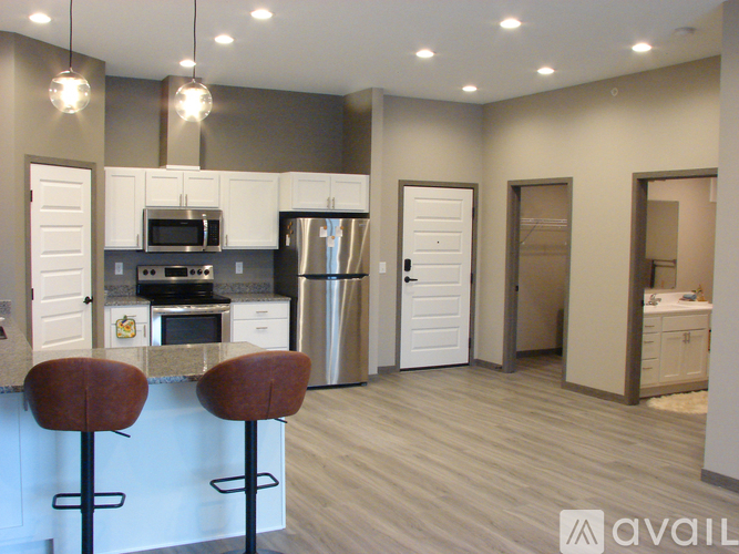 A kitchen with a bar stool in front of it.
