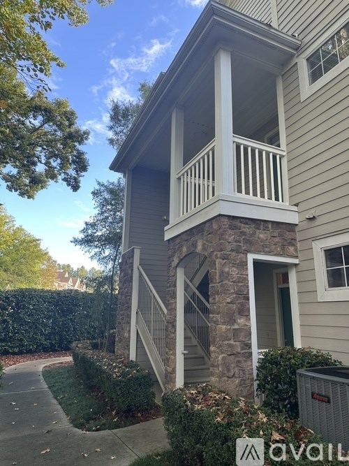 A house with a balcony and a stone pillar.