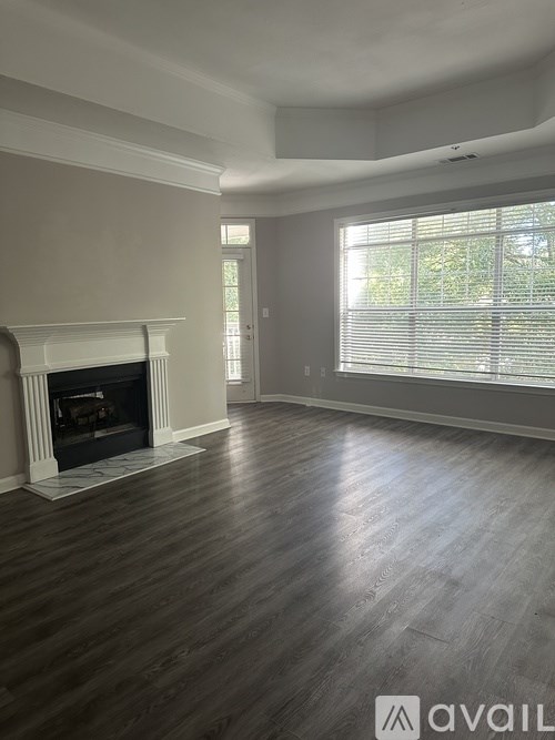 A living room with a fireplace and wood flooring.