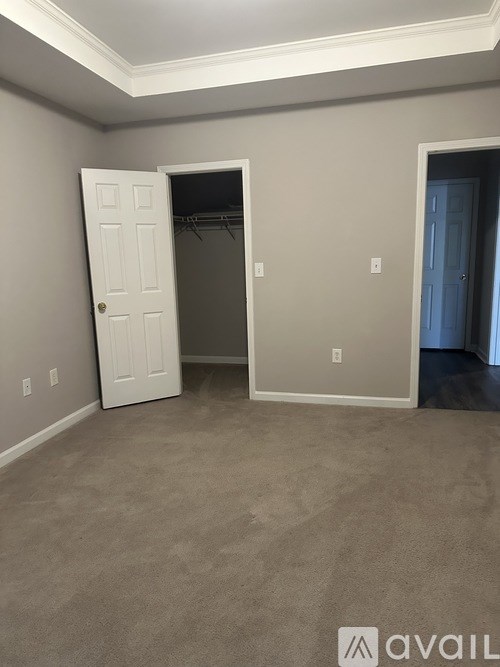 A room with a white door and a grey wall.