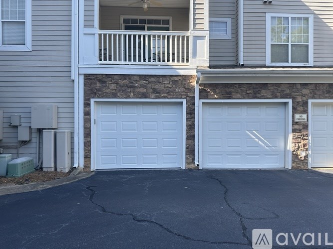 A house with a balcony and three garage doors.