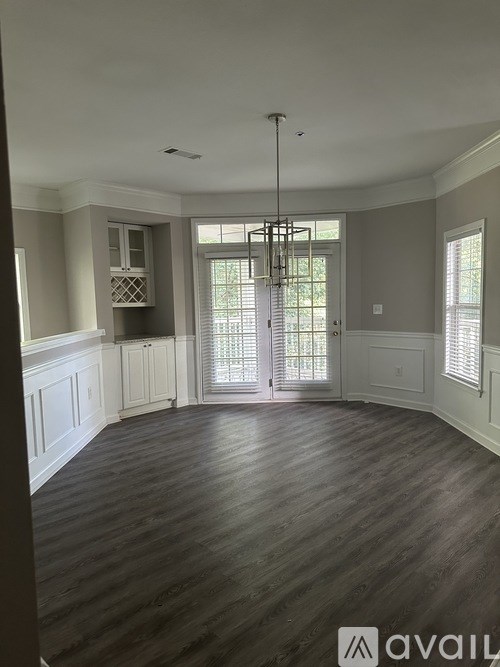 A large empty room with wooden floors and a chandelier.
