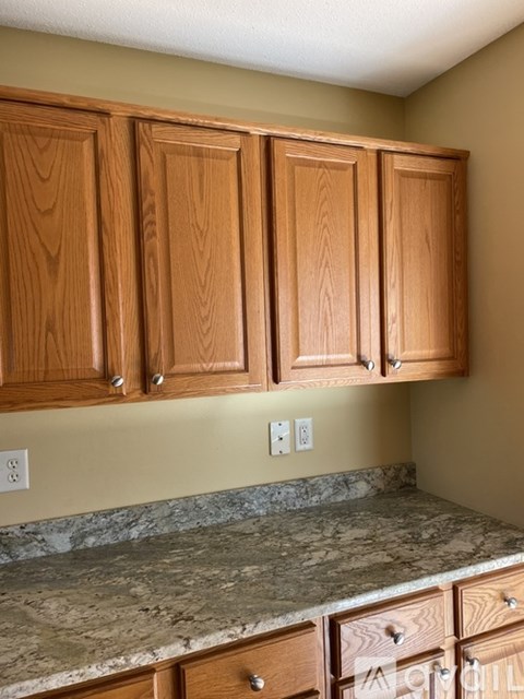 A kitchen with wooden cabinets and granite countertops.