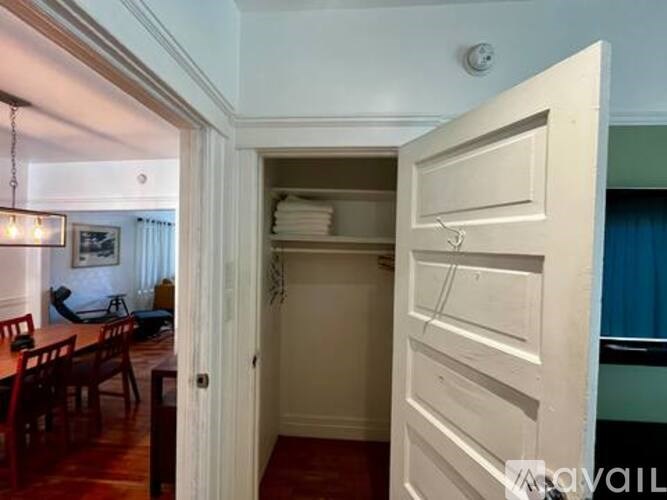 A white door is open to a room with a dining table and chairs.