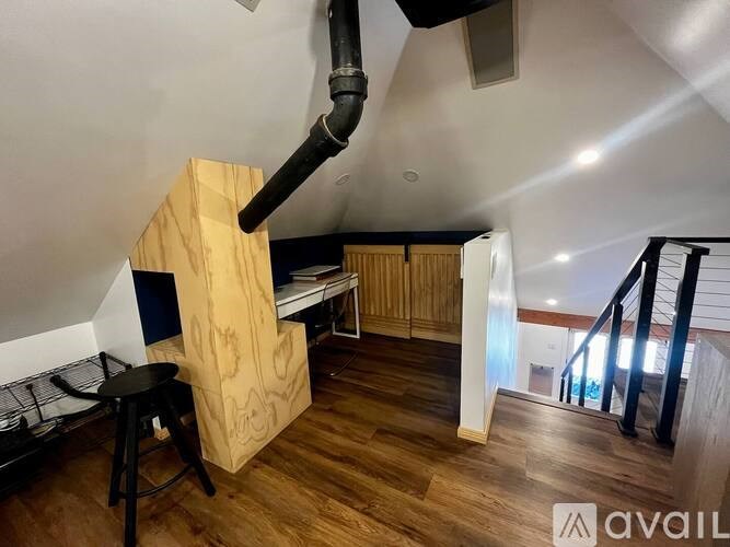 A room with wooden floors and a black pipe on the ceiling.