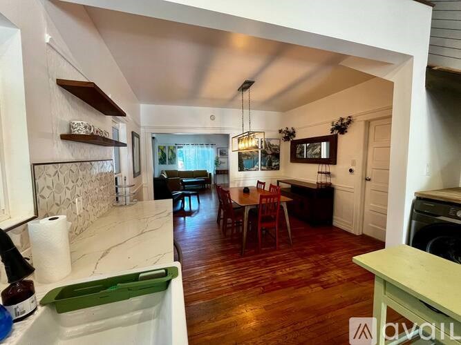 A kitchen with a dining table and chairs in the middle of the room.