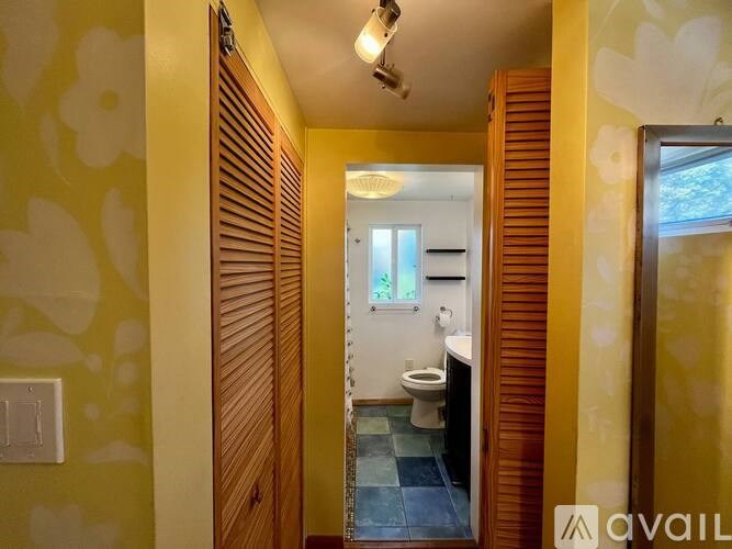 A bathroom with a toilet and a mirror.